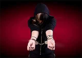 Handcuffed person wearing a black hoodie