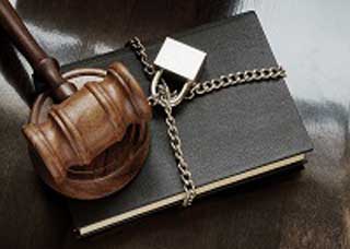 Image of a padlocked chain wrapped around a legal book with a gavel