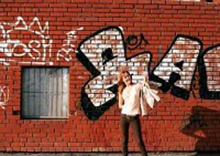 Image of a teen standing in front of graffiti
